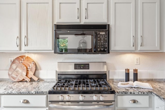 kitchen featuring light stone counters, white cabinets, and stainless steel gas stove