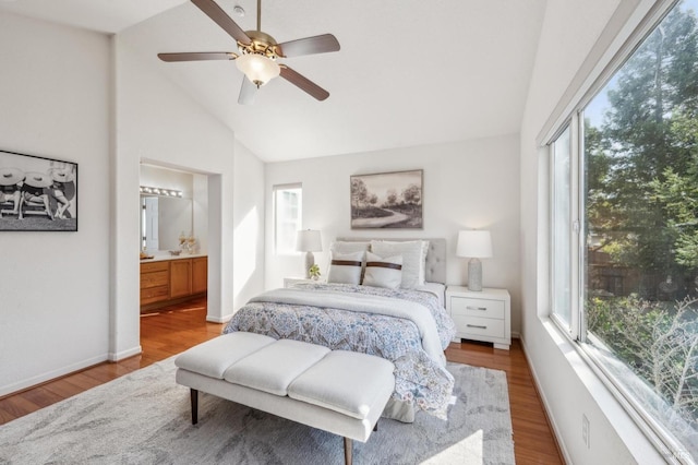 bedroom with hardwood / wood-style flooring, ensuite bath, ceiling fan, and vaulted ceiling