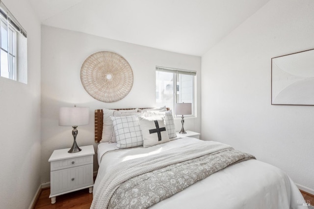 bedroom with dark hardwood / wood-style flooring and lofted ceiling