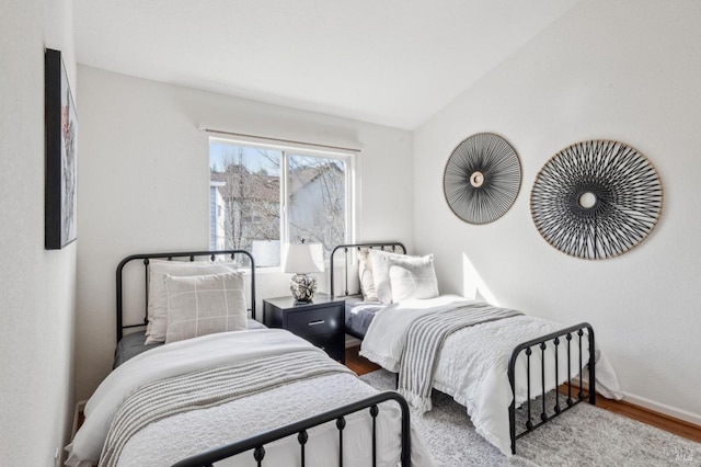 bedroom featuring hardwood / wood-style flooring and lofted ceiling