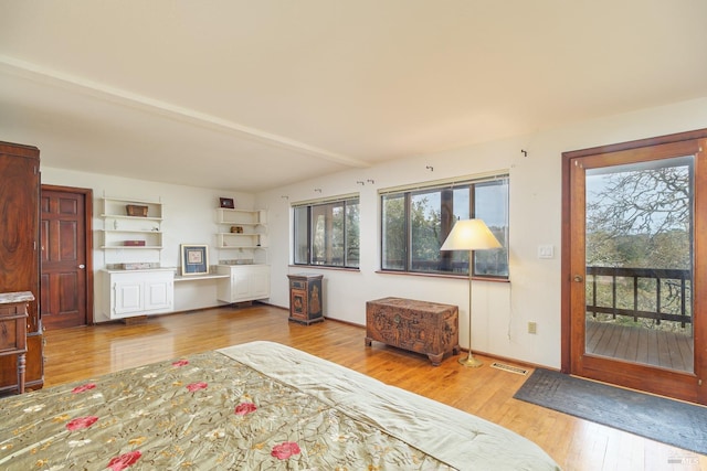 interior space featuring access to outside, hardwood / wood-style flooring, visible vents, and baseboards