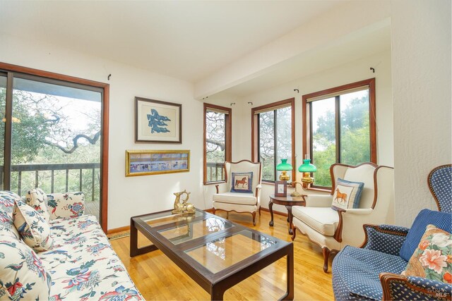 living area with light wood-type flooring and baseboards