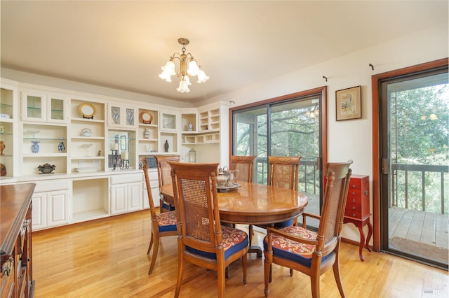 dining room featuring a wealth of natural light, a notable chandelier, and light wood finished floors