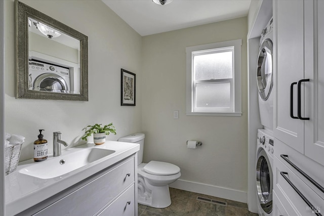 bathroom featuring stacked washer and dryer, vanity, and toilet