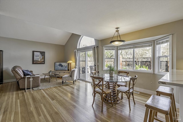 dining area featuring light hardwood / wood-style floors and vaulted ceiling