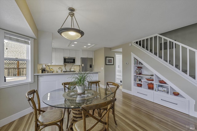 dining area featuring built in shelves and light hardwood / wood-style flooring