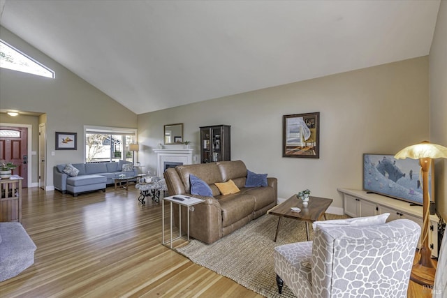 living room with high vaulted ceiling and light hardwood / wood-style flooring