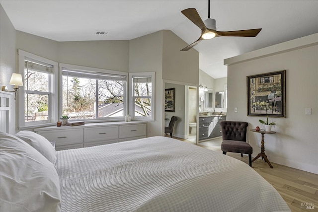 bedroom with connected bathroom, vaulted ceiling, light hardwood / wood-style floors, and ceiling fan