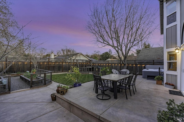 patio terrace at dusk with a hot tub