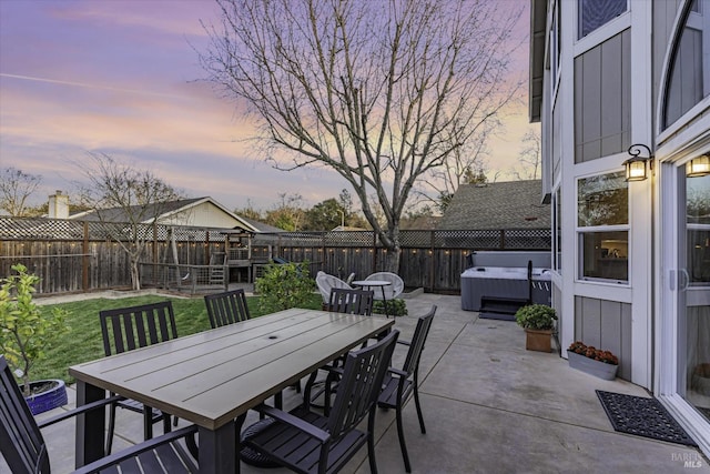 patio terrace at dusk with a hot tub