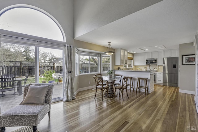 dining room with sink, hardwood / wood-style floors, and a textured ceiling