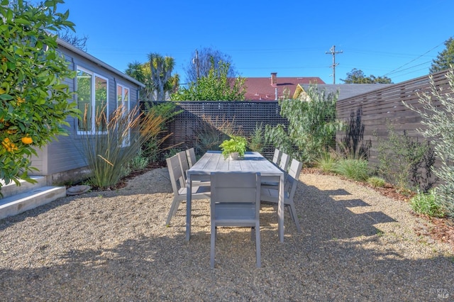 view of yard featuring outdoor dining area and fence