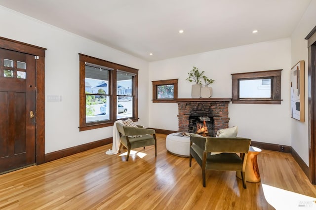 sitting room featuring light wood-style floors, a fireplace, and baseboards