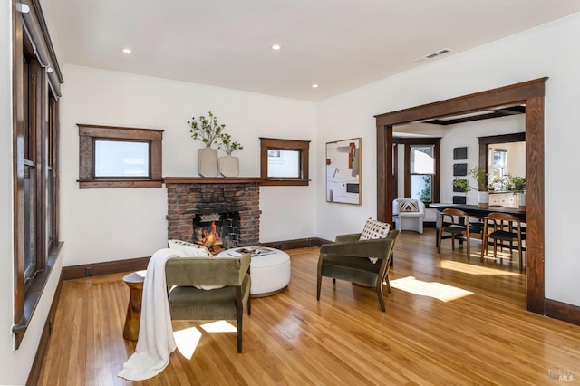 sitting room with recessed lighting, visible vents, a brick fireplace, light wood-type flooring, and baseboards