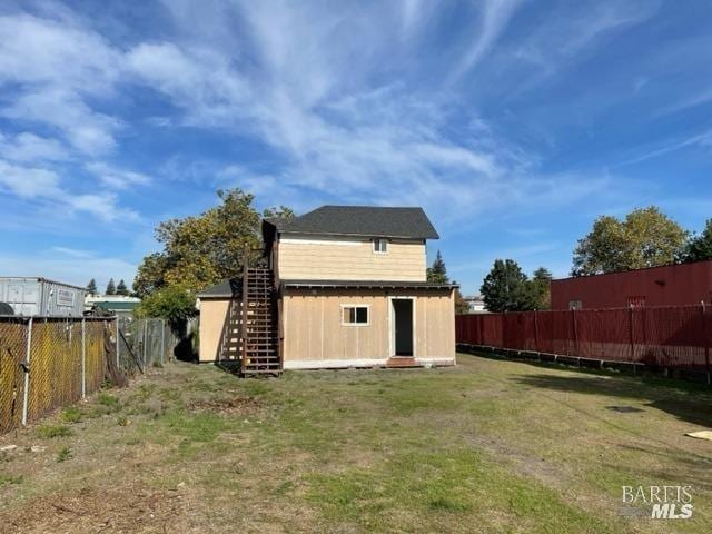 rear view of property with a yard and an outdoor structure