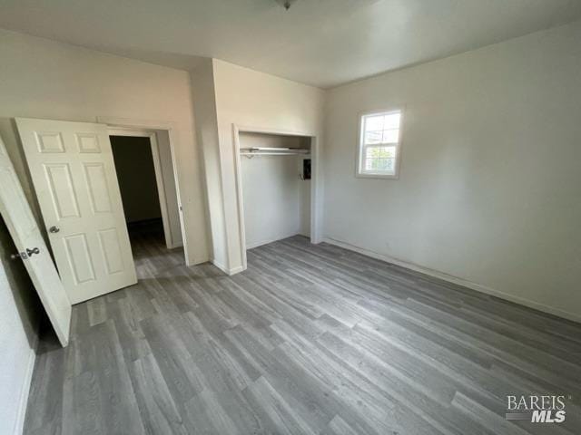 unfurnished bedroom with hardwood / wood-style floors and a closet