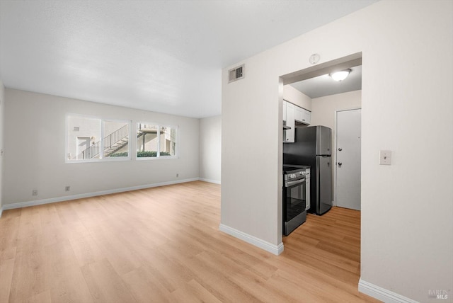 kitchen featuring light wood-type flooring, white cabinets, and appliances with stainless steel finishes