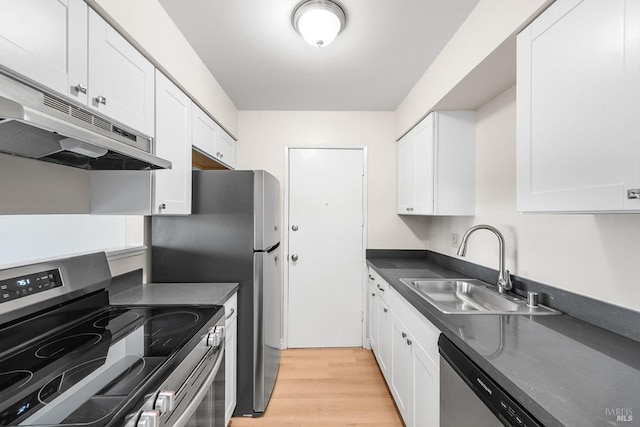 kitchen with stainless steel appliances, sink, white cabinets, and light hardwood / wood-style floors