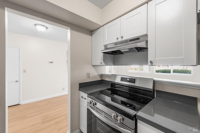 kitchen featuring stainless steel electric stove, light hardwood / wood-style floors, and white cabinets