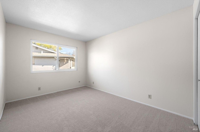 spare room with carpet flooring and a textured ceiling