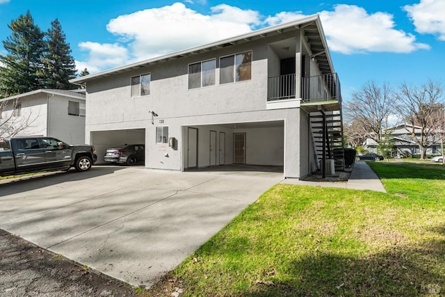 view of side of home featuring a garage, a balcony, and a lawn