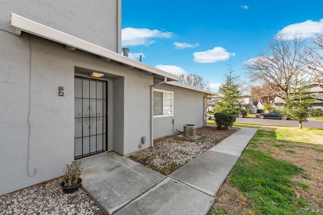 view of exterior entry with a lawn