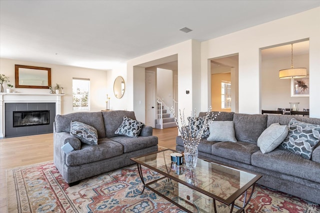 living room with hardwood / wood-style flooring and a tiled fireplace