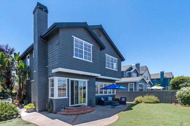 rear view of property with an outdoor living space, a lawn, and a patio area