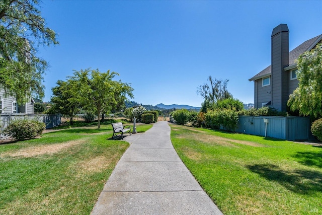 surrounding community with a mountain view and a yard