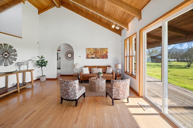 living room with beam ceiling, light hardwood / wood-style floors, and wooden ceiling