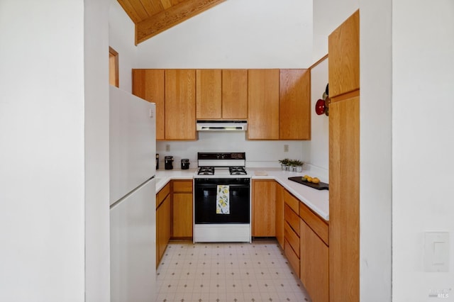 kitchen with range with gas stovetop, white fridge, and vaulted ceiling with beams