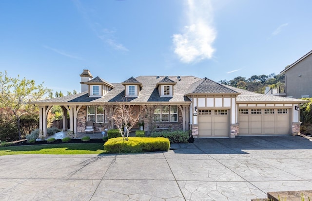 view of front of property with a garage, stone siding, driveway, and stucco siding