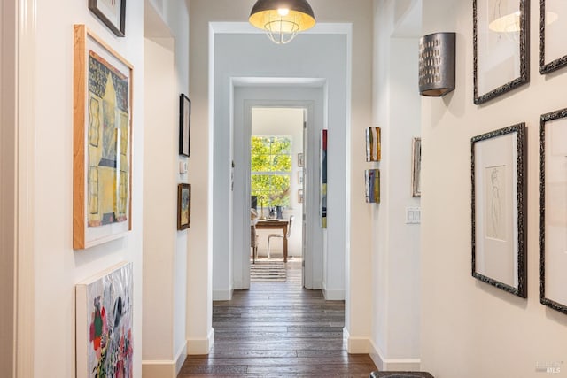 corridor with baseboards and dark wood-style flooring