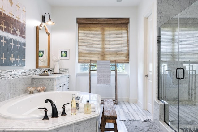 full bathroom with a stall shower, baseboards, a bath, and vanity