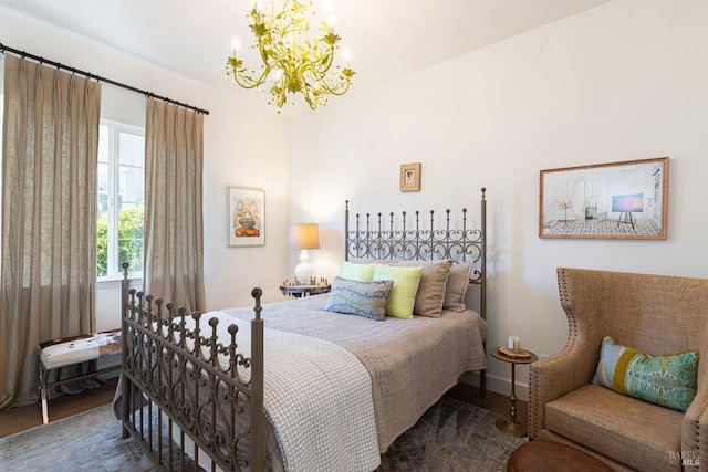 bedroom with wood finished floors and an inviting chandelier