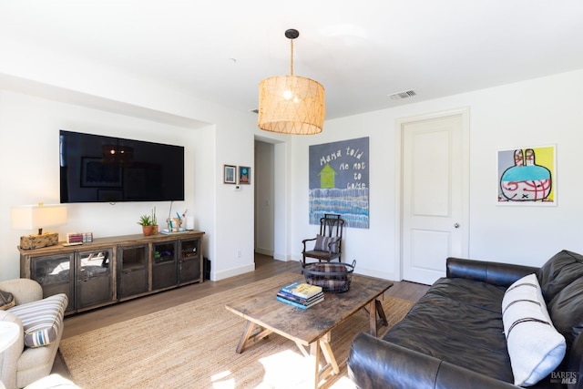 living area featuring wood finished floors, visible vents, and baseboards