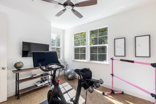 workout room with ceiling fan and baseboards