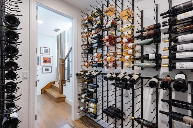 wine room with baseboards, visible vents, and wood finished floors