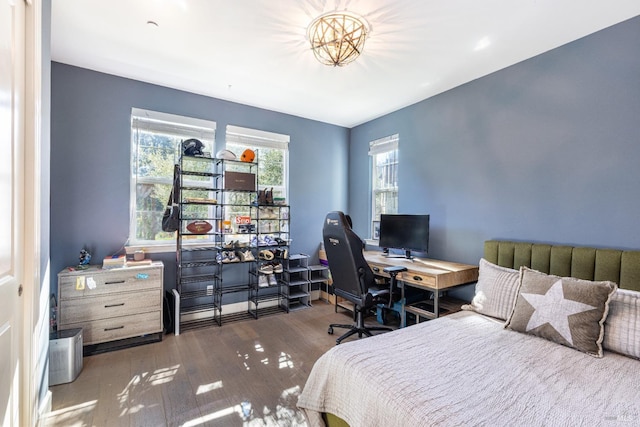 bedroom with multiple windows and dark wood finished floors