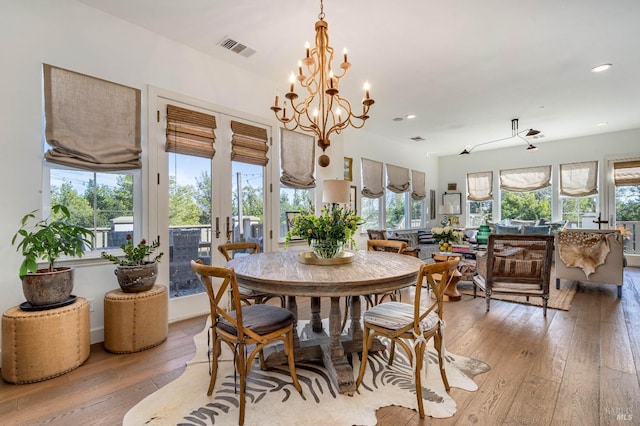 dining area with light wood-type flooring, plenty of natural light, and visible vents