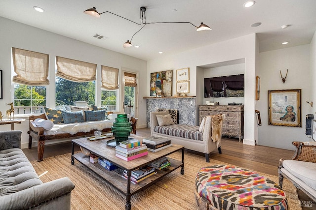 living room featuring light wood-type flooring, a healthy amount of sunlight, visible vents, and recessed lighting