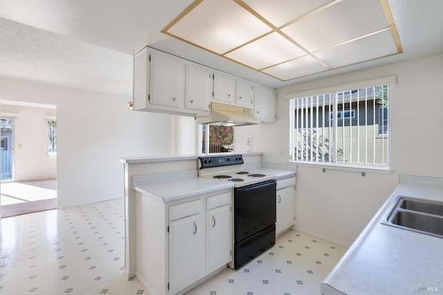 kitchen with white cabinetry, electric range, and kitchen peninsula