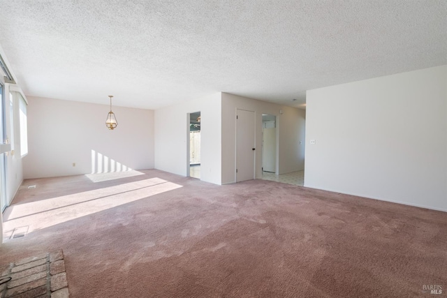 carpeted empty room featuring a textured ceiling