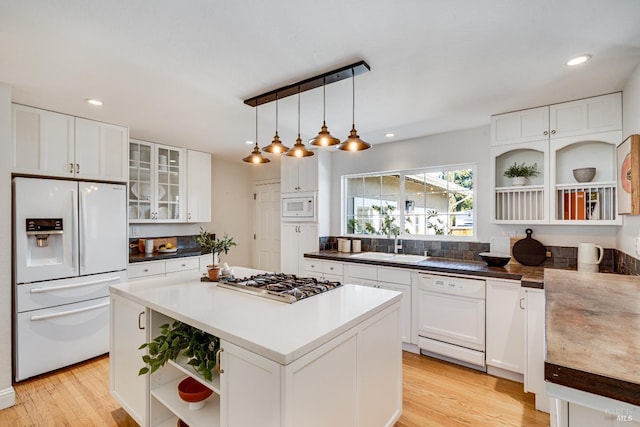 1077 Valley View St, Saint Helena, CA 94574 - kitchen with white appliances, open shelves, light wood-style floors, white cabinetry, and a kitchen island
