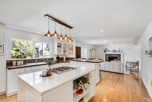 1077 Valley View St, Saint Helena, CA 94574 - kitchen featuring open shelves, a peninsula, stainless steel gas cooktop, light wood-style flooring, and a kitchen island