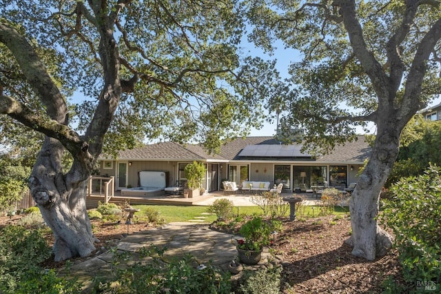 rear view of house with a patio and solar panels