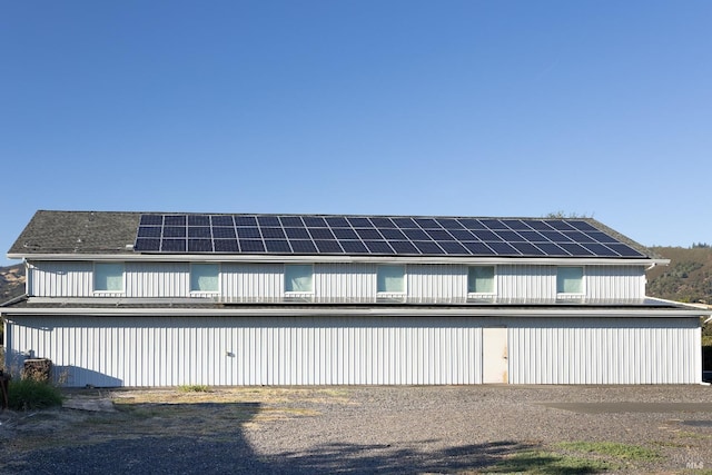 rear view of property with roof mounted solar panels