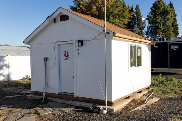 view of outbuilding featuring fence and an outbuilding