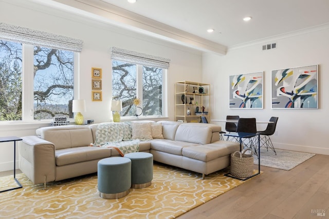 living room featuring crown molding, light hardwood / wood-style floors, and beamed ceiling