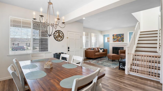 dining area with a wealth of natural light, stairs, and wood finished floors